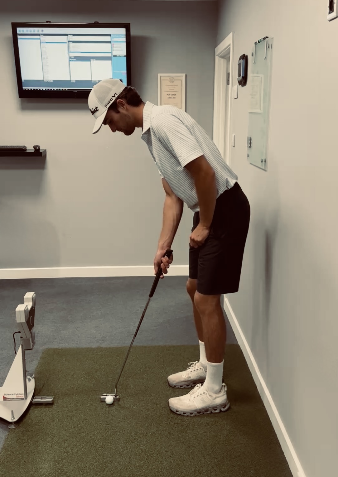 Golfer putting on the studio mat while SAM PuttLab records the putter's movement