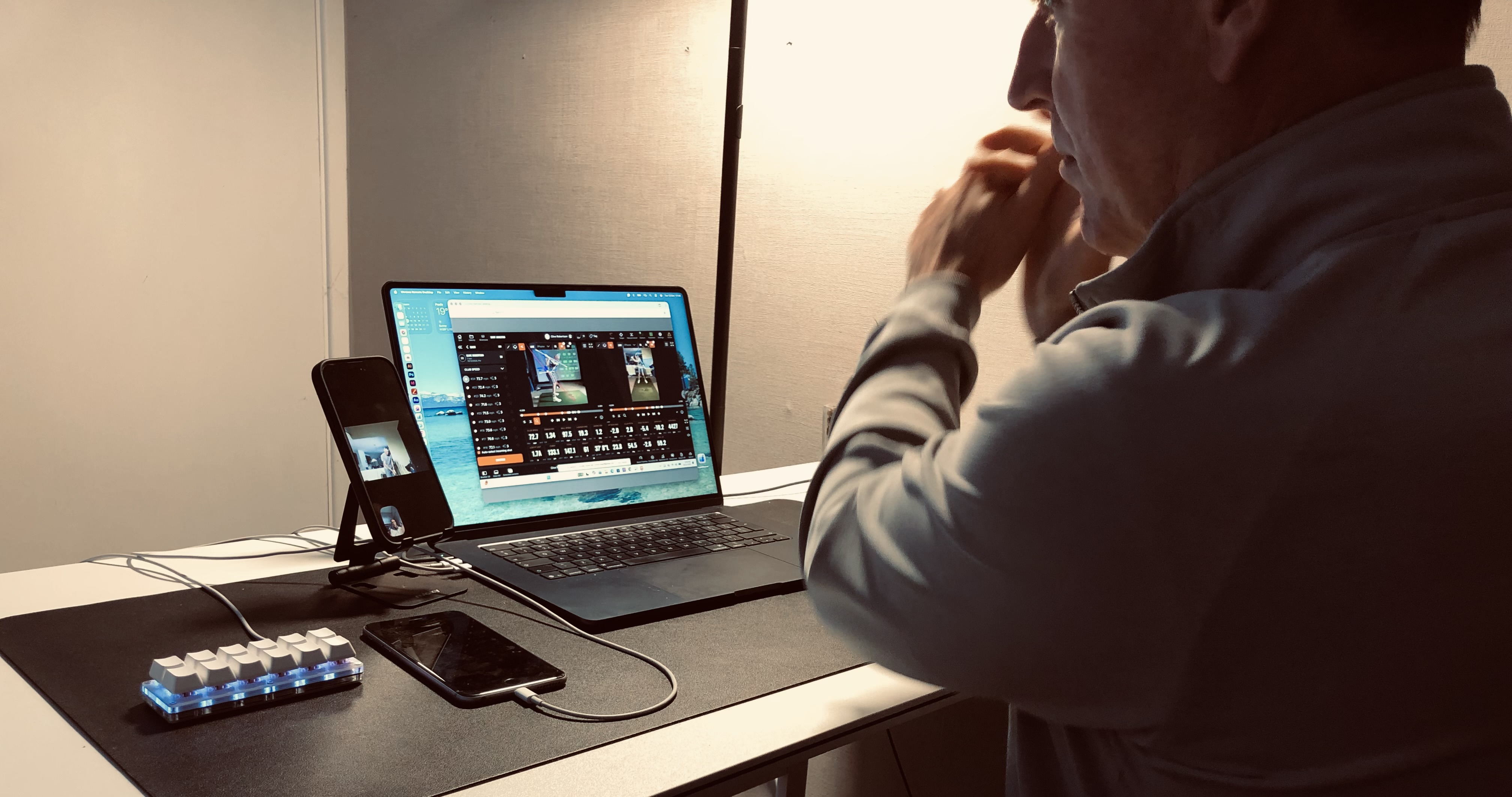 Chris Brook coaching a golfer live online from his laptop and launch-monitor setup in the Dorset studio
